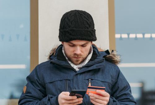 Persona effettua acquisto online da smartphone con carta di credito