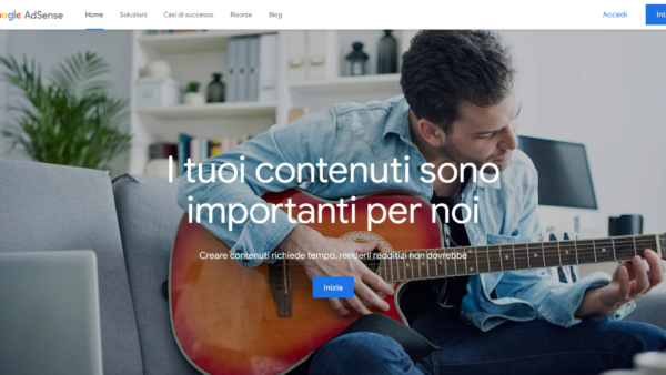 Uomo suona chitarra seduto su divano.