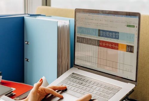 Professionista confronta piattaforme CRM su laptop per la scelta aziendale