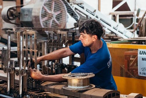 Operatore industriale utilizza macchinari in fabbrica con gestionale ERP