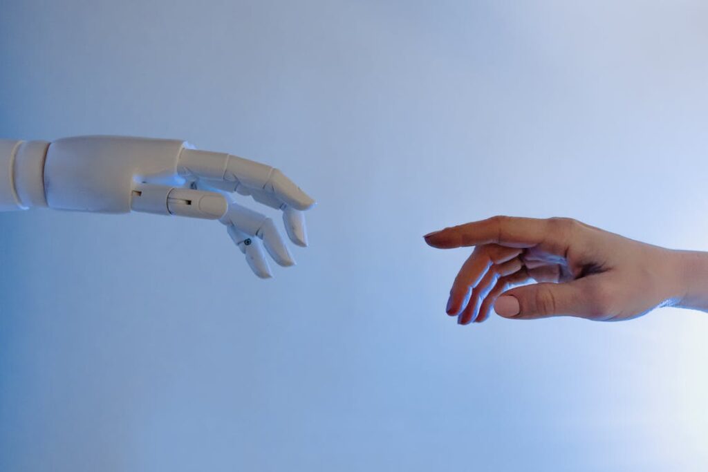 Mano umana raggiunge un robot simboleggiando il futuro AI dei gestionali